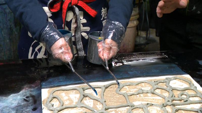 両手にやかんを持って注ぐ作業
