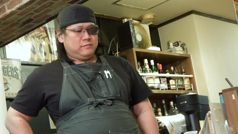 腰に手をやって立っているオーナーの望月さん
