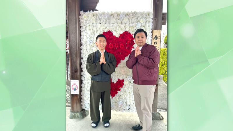 山門で写真を撮る副住職とにむらリポーター