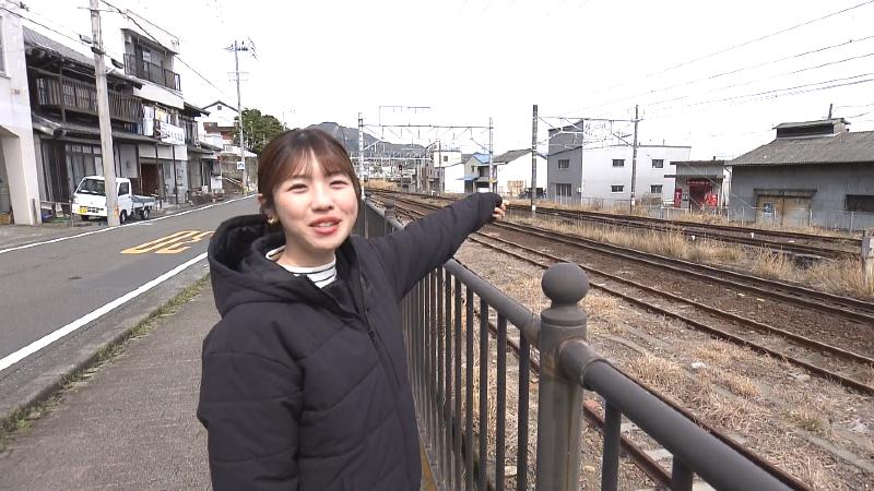 線路の反対側にあるヤマボシ水産を指す大森アナ