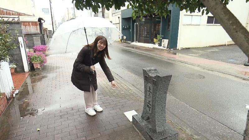 町碑を指さす大森アナ