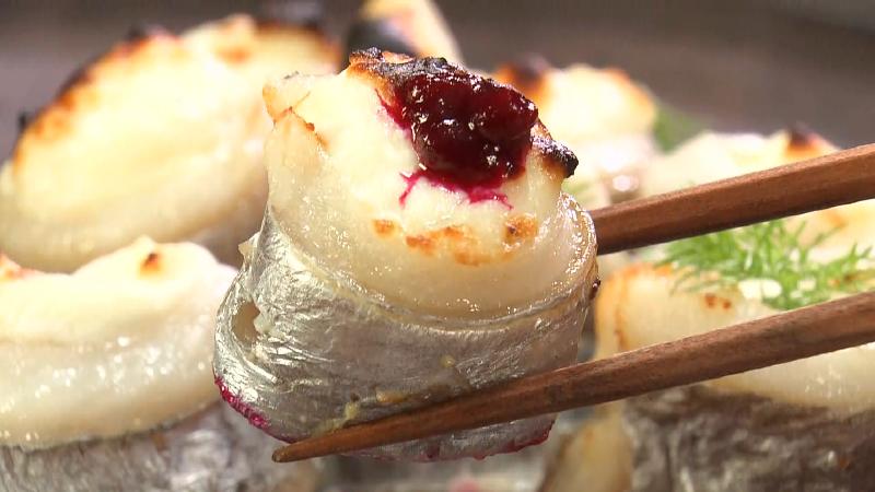 タチウオの自家製クリームチーズ包み焼きにソースを付けて