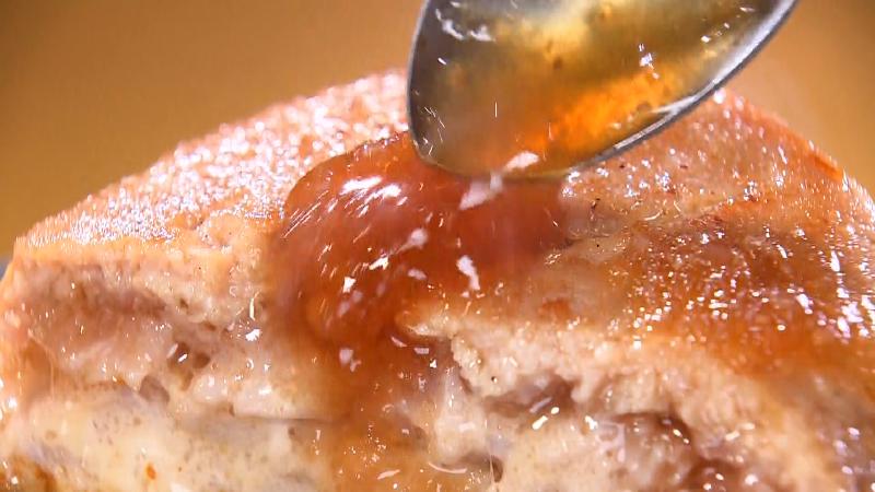 まぐろハンバーグにオニオンソースをかける