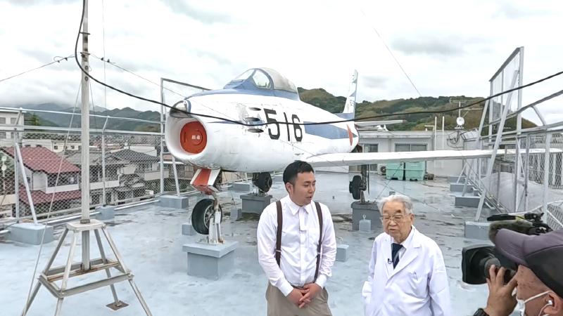 戦闘機の前に立つ菅野先生とにむらリポーター