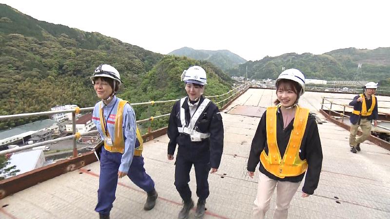 道を上る大森アナと関係者