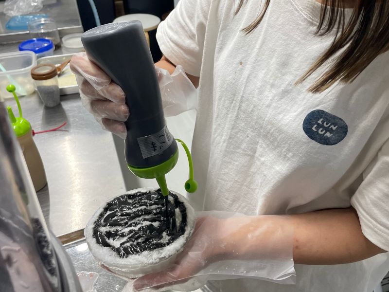 黒いシロップをかける様子