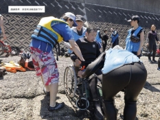 海に入る車イスの人