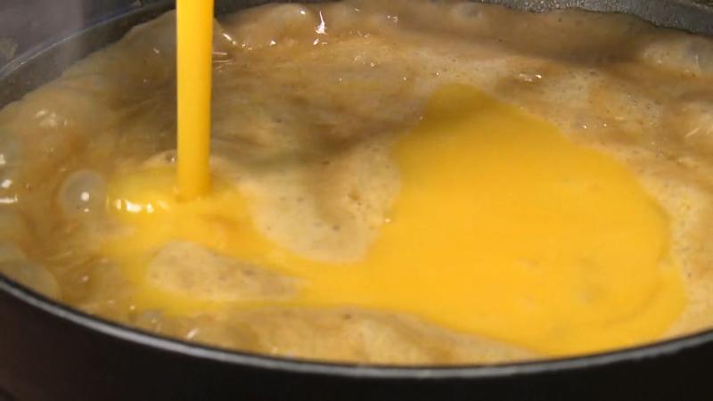 リゾットに卵を入れている