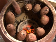 焼きいも専用のツボでサツマイモを焼いている