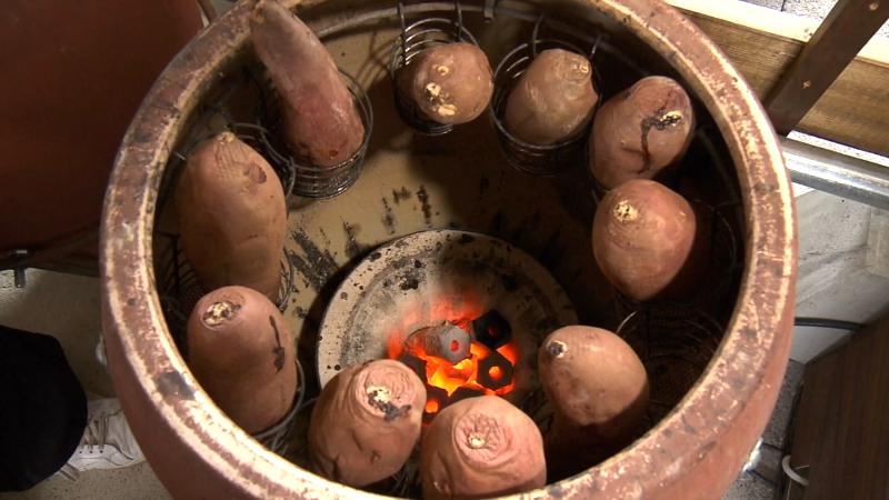 焼きいも専用のツボでサツマイモを焼いている
