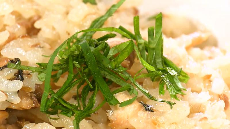 サンマの釜めしに薬味の大葉を乗せている