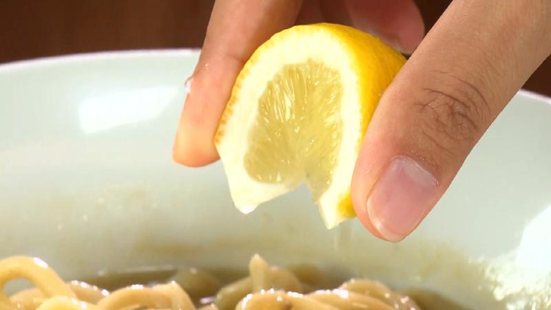 トッピングのレモンをラーメンに絞っている