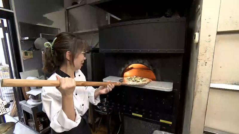 ガス窯にピザをいれている