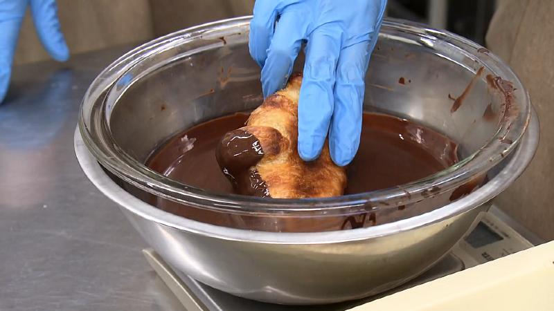 クロワッサンにチョコレートをつける様子