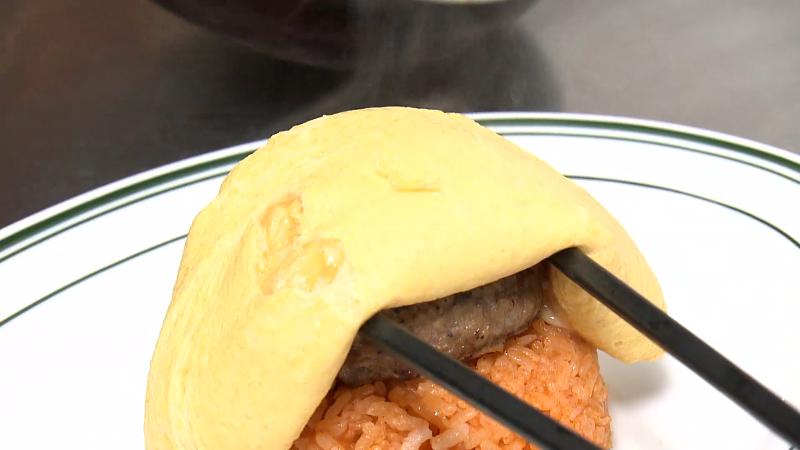 ハンバーグの上に卵を置く　調理風景