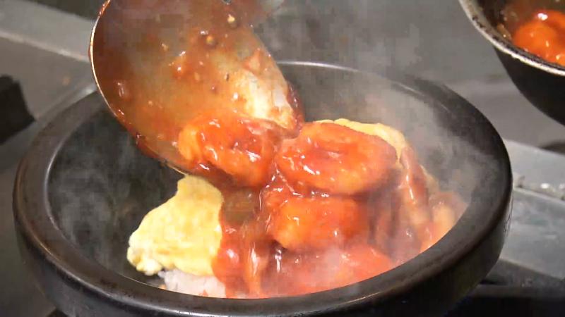 オムライスにエビチリをかける　調理風景