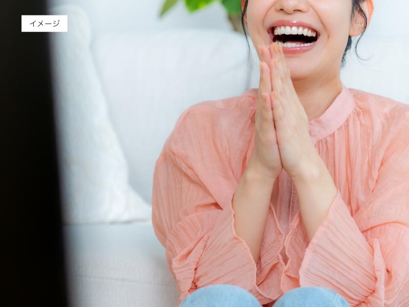 イメージ画像：テレビを見て笑う女性