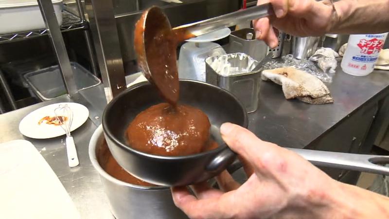 煮込みハンバーグにデミグラスソースをかける調理工程