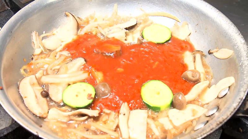 トマトソースと野菜を混ぜる調理工程