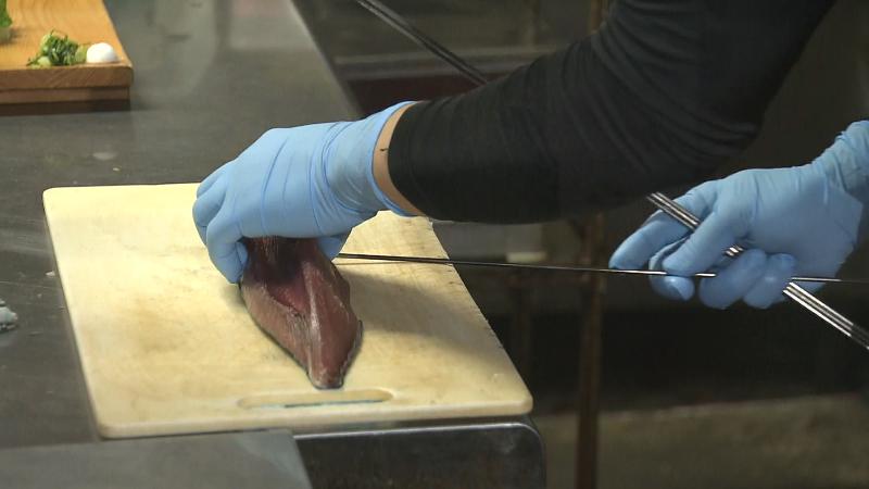 カツオの切り身に串を刺す料理工程