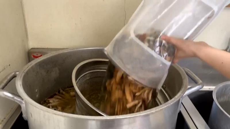 スープに魚介だしを加える調理風景