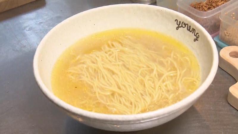 スープに麺を入れる調理風景