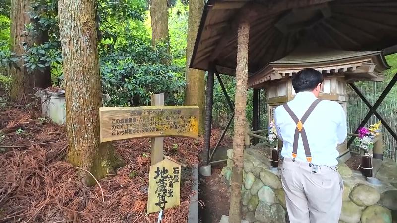 すべらず地蔵尊に手を合わせるにむらリポーター